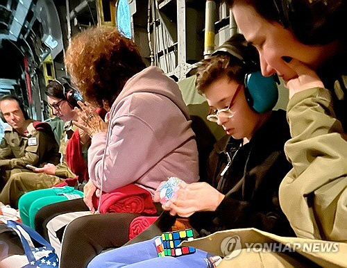 하마스에 인질로 잡혔다가 풀려난 이스라엘 소년 오하드 먼더가 24일(현지시간) 이스라엘 군용 헬기 안에서 큐브를 갖고 놀고 있다. [이스라엘 총리실 제공. 로이터=연합뉴스]